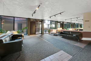 Lobby featuring floor to ceiling windows and a textured ceiling