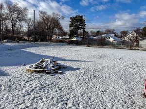 Yard layered in snow with an outdoor fire pit