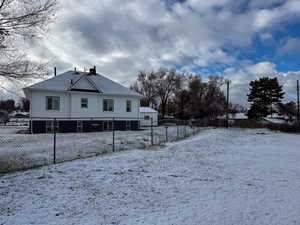 Snow covered property featuring a chimney and roof with shingles