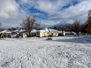 Yard layered in snow featuring a residential view and a mountain view