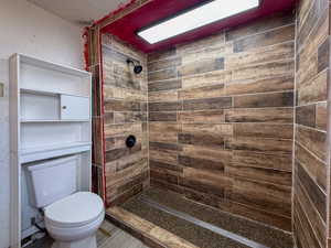 Bathroom with tiled shower and a textured wall