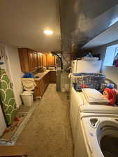 Finished basement with light carpet, recessed lighting, heating unit, and washer and clothes dryer