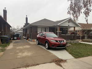 View of front of home featuring brick siding and roof with shingles