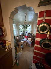 Dining space featuring dark tile patterned floors, a textured wall, and arched walkways