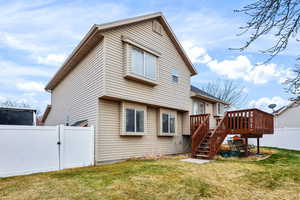 Rear view of house with a fenced backyard, a gate, stairway, and a deck