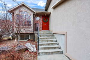 Doorway to property featuring stucco siding and brick siding