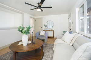Living room featuring light wood-type flooring and a ceiling fan