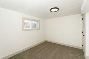 Carpeted empty room with baseboards