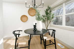 Dining room with light wood finished floors and a chandelier