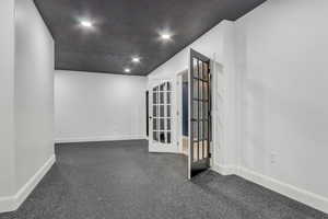 Empty room featuring baseboards and french doors