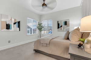 Carpeted bedroom featuring baseboards and a ceiling fan