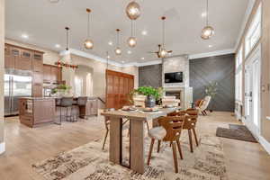 Dining area with an accent wall, arched walkways, light wood-style flooring, ceiling fan, and recessed lighting