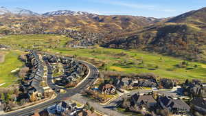 Aerial view of property's location featuring a mountainous background, nearby suburban area, and a golf course