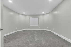 Carpeted empty room featuring baseboards and recessed lighting