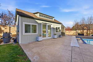 Back of house featuring a patio area, a fenced backyard, french doors, and a shingled roof