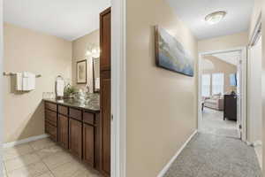Hall featuring baseboards and light colored carpet