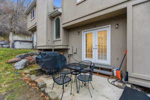 View of patio with french doors, grilling area, and outdoor dining area