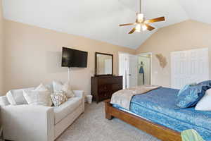 Carpeted bedroom featuring lofted ceiling, a ceiling fan, and a closet