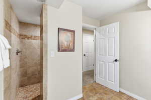 Bathroom featuring a walk in shower and baseboards