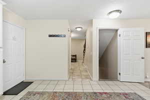 Foyer featuring light tile patterned floors and a textured ceiling