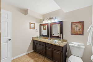 Full bath featuring double vanity and light tile patterned floors
