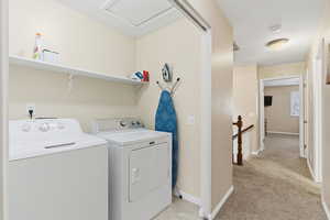 Washroom with separate washer and dryer and light carpet