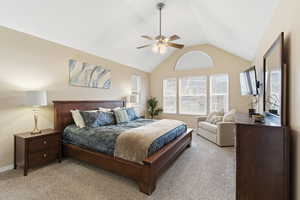 Bedroom featuring lofted ceiling, a ceiling fan, and carpet