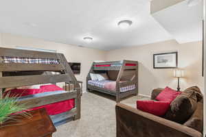 Carpeted bedroom with a textured ceiling and baseboards