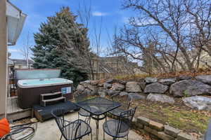 View of patio featuring a hot tub and outdoor dining area