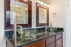 Bathroom featuring a stall shower and double vanity