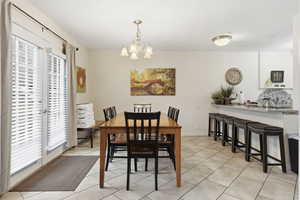 Dining space with a chandelier and light tile patterned floors