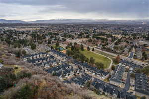 Aerial view of property and surrounding area with nearby suburban area and mountains