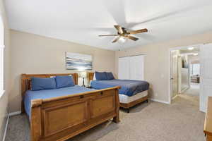 Bedroom featuring light carpet, a closet, and ceiling fan
