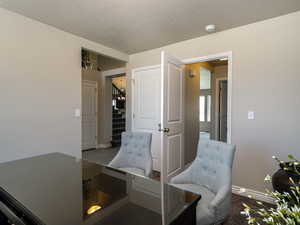 Living area featuring a textured ceiling and stairway