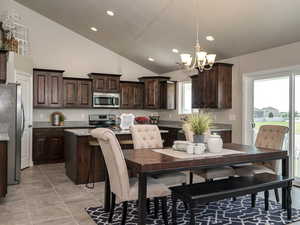 Dining space with light tile patterned floors, high vaulted ceiling, recessed lighting, and a chandelier