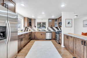 Kitchen featuring appliances with stainless steel finishes, brown cabinets, granite countertops