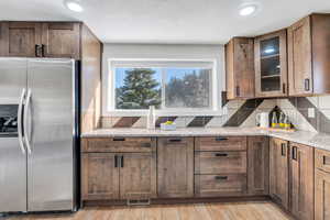 Kitchen featuring appliances with stainless steel finishes, brown cabinets, granite countertops