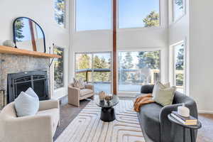 Carpeted living area featuring a brick fireplace, high ceiling, and fireplace
