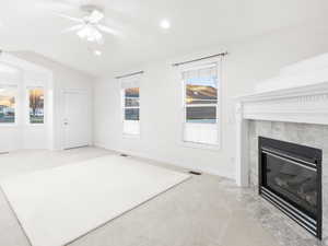 Unfurnished living room with lofted ceiling, carpet, a ceiling fan, recessed lighting, and a premium fireplace