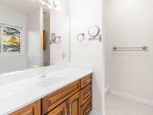 Full bath featuring light tile patterned floors and vanity