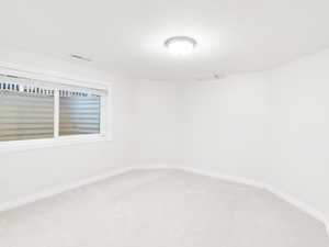 Unfurnished room with carpet and baseboards
