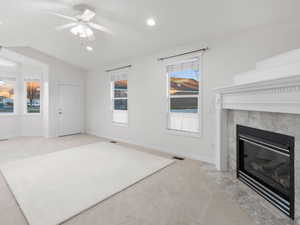 Living room with light carpet, vaulted ceiling, a ceiling fan, a premium fireplace, and recessed lighting