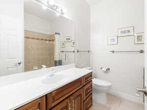Full bathroom featuring light tile patterned floors, vanity, and curtained shower