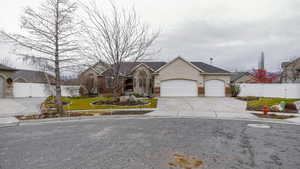 Ranch-style home featuring concrete driveway, stucco siding, and an attached garage
