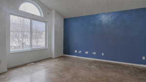 Spare room featuring baseboards and vaulted ceiling
