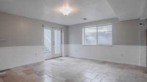 Spare room with french doors and stone tile floors