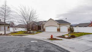View of front facade featuring driveway, stucco siding, and an attached garage