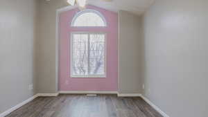Foyer entrance featuring a ceiling fan, dark wood-type flooring, and vaulted ceiling