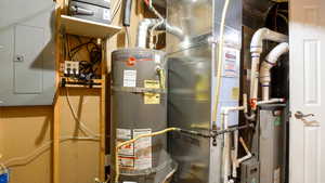 Utility room with electric panel, heating unit, and water heater