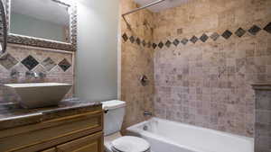 Bathroom featuring vanity and washtub / shower combination